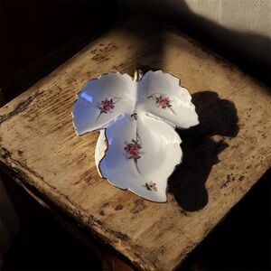 This is a vintage three-compartment porcelain leaf-shaped dish
